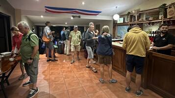 A group of people in a restaurant setting with a bar area and a counter.