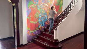 Una escalera con un mural colorido en la pared.