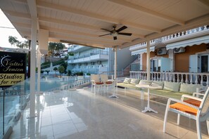 An outdoor lounge area with seating, a pool, and a sign for 'Studio Valto's London Studios for rent'. - Valtos Ionion (Parga)
