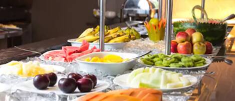 Un bufé con diversas frutas y verduras sobre hielo.