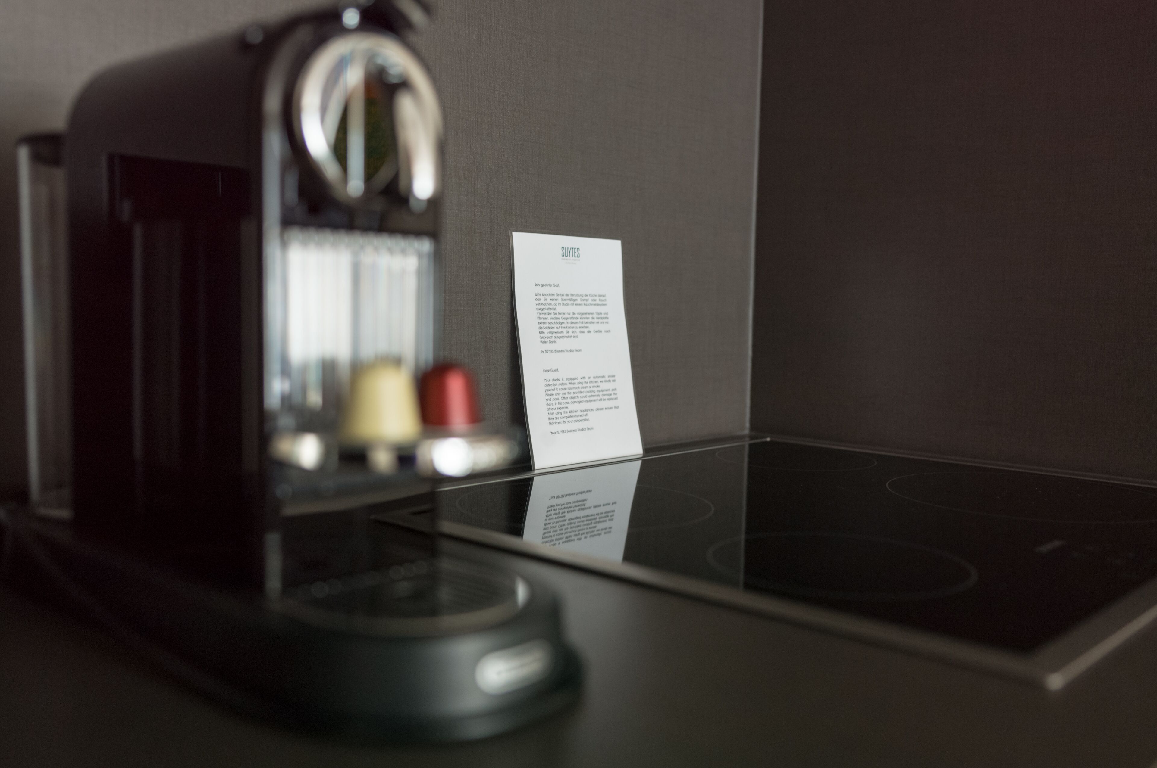 Eine moderne Küche mit Einbauherd und Kaffeemaschine.