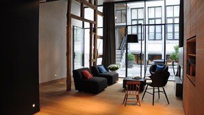 Un intérieur moderne avec une grande fenêtre, un ensemble de canapés, une table basse et un fauteuil.