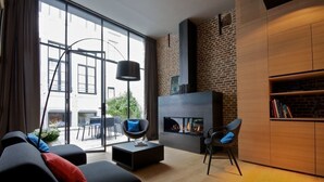Un salon moderne avec une cheminée, un canapé, une table basse et une bibliothèque.