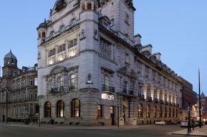 Un edificio storico con un evidente cartello 'Alloft', ampie finestre e dettagli architettonici classici.