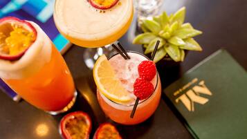 Tre cocktail con guarnizioni di frutta su un tavolo.