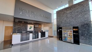 Un área de recepción de hotel moderna con una pared de piedra y un letrero grande que dice "Hotel Diego de Almagro Alto el Loo".