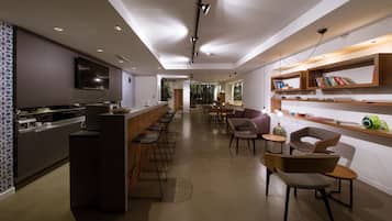 Een modern interieur met een bar, zitplaatsen en een televisie.