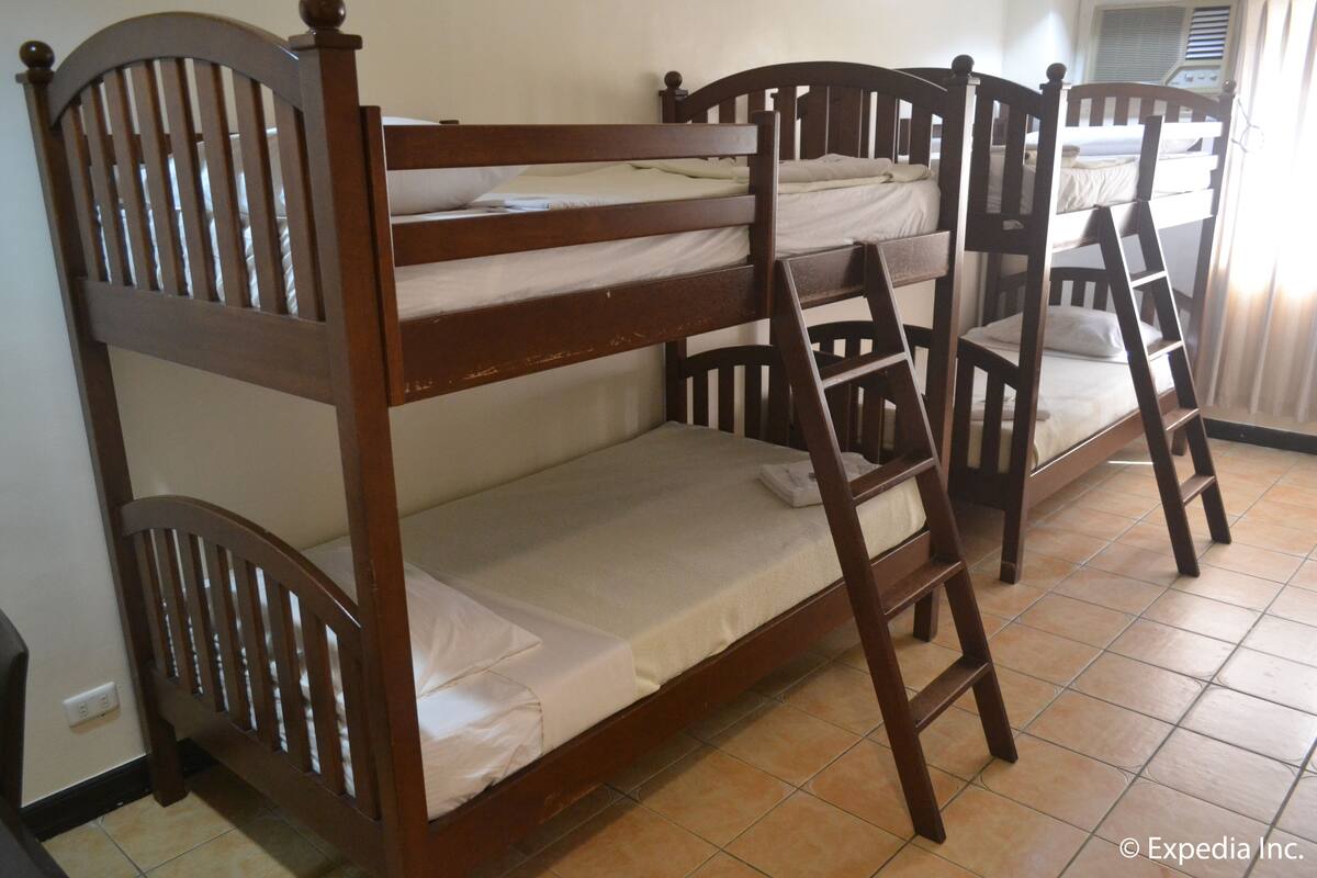 Uma cama beliche com cabeceiras de madeira e uma escada.