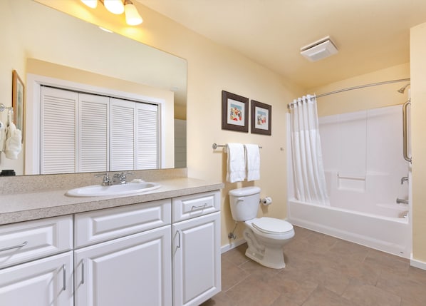 A modern bathroom with a sink, toilet, and bathtub.