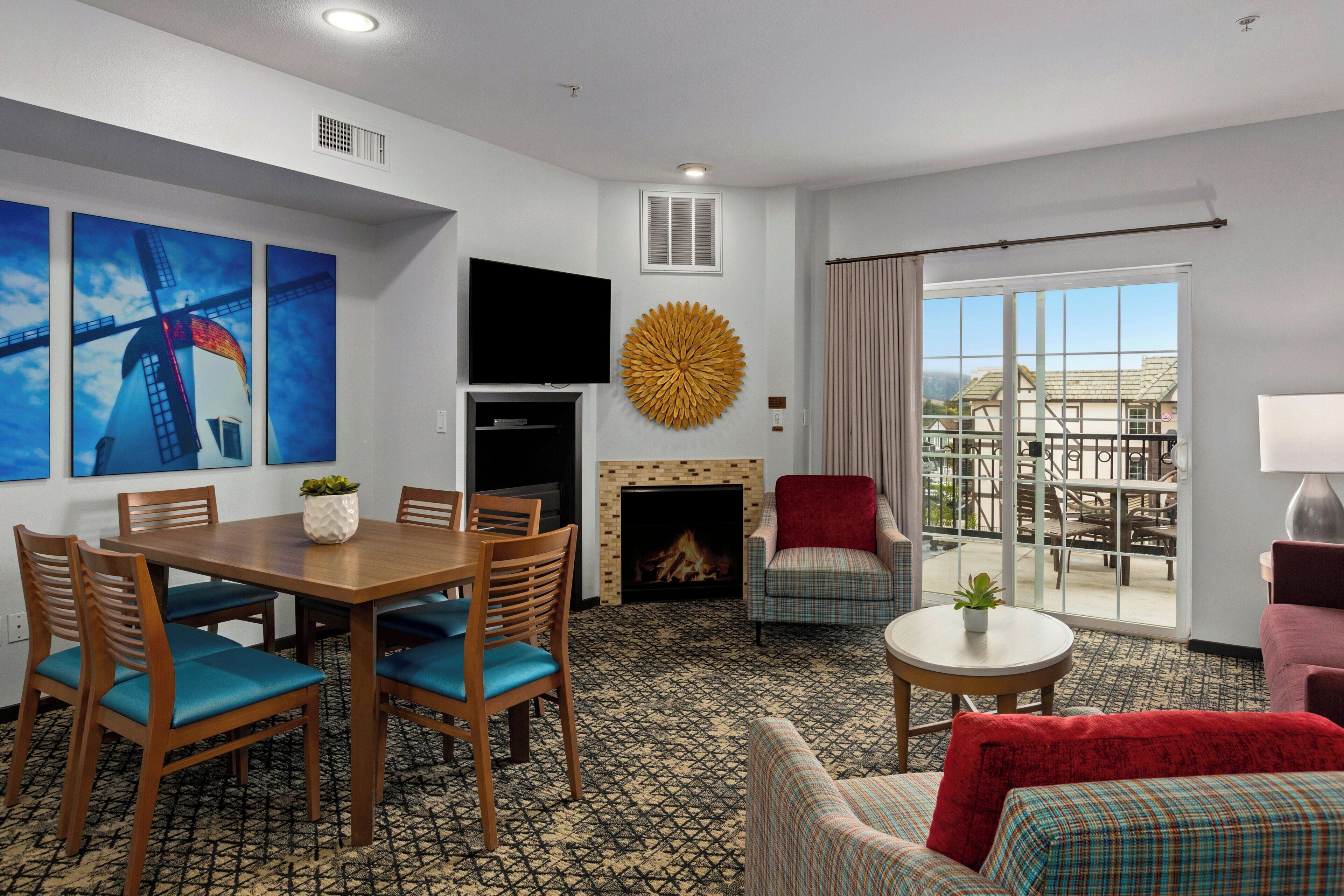 Une chambre d’hôtel avec un coin repas, une cheminée, une télévision et un balcon avec vue.