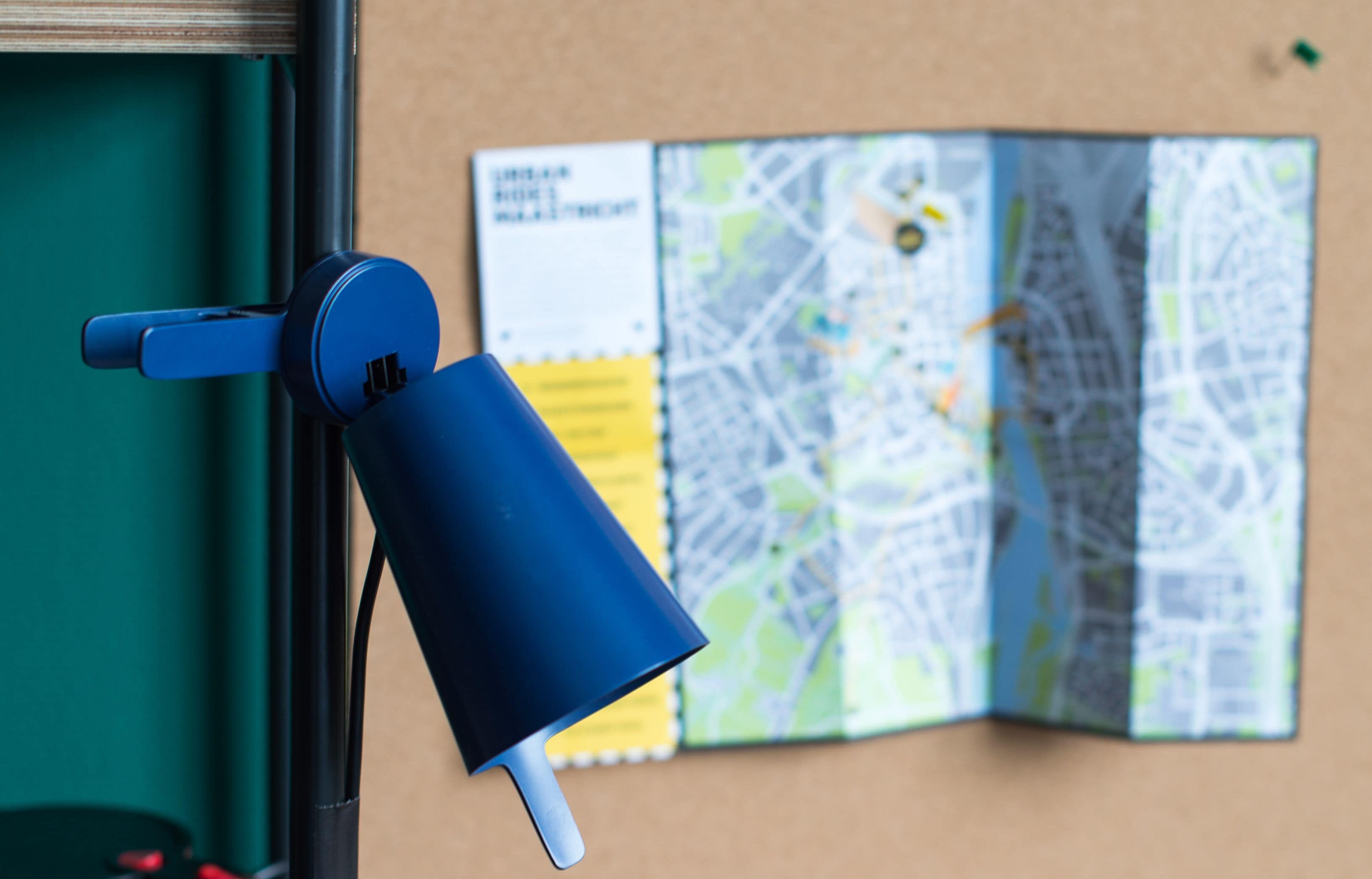A blue object attached to a wall with a map in the background.