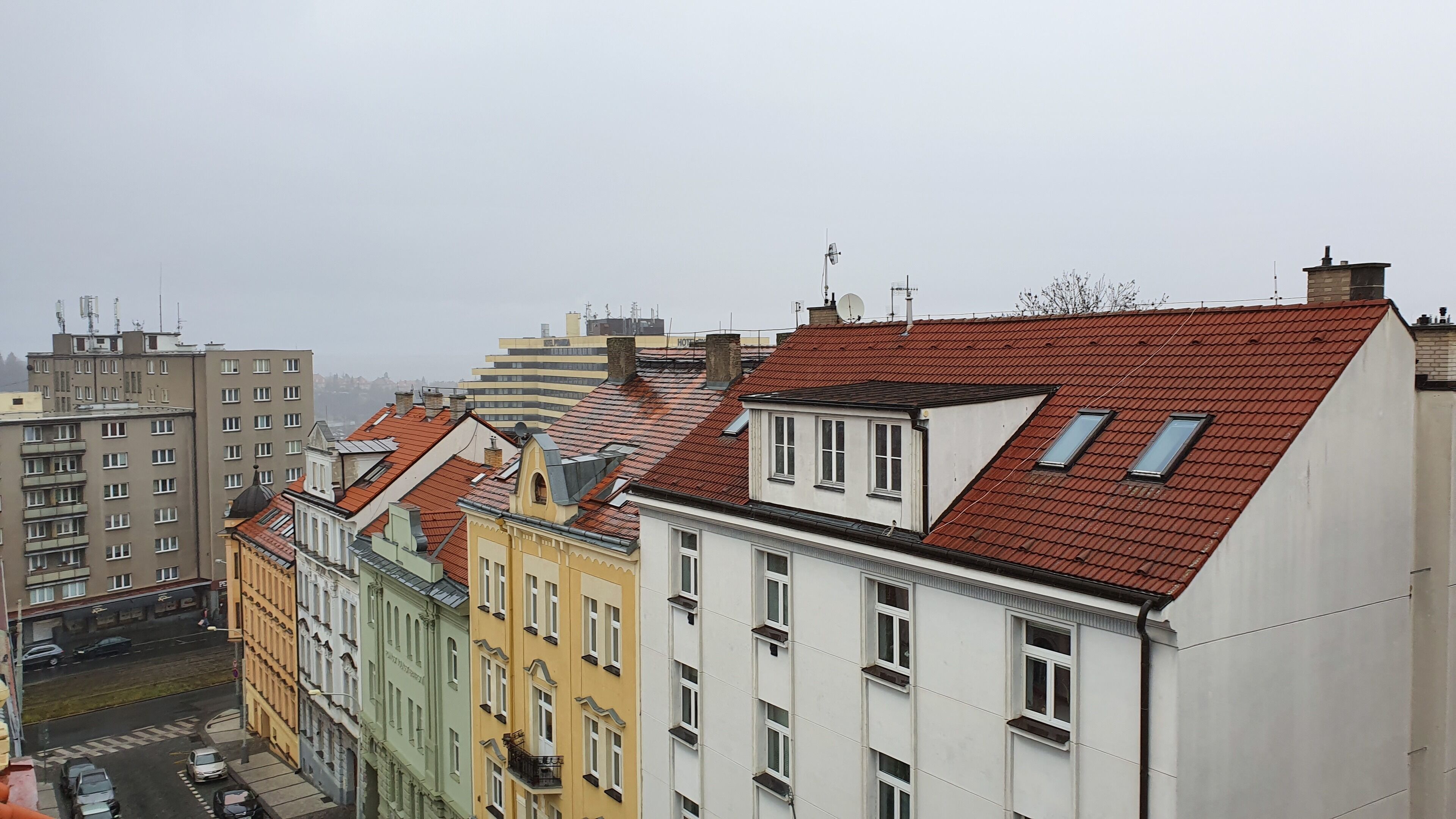 Una hilera de edificios de varios pisos con tejados rojos y diferentes estilos arquitectónicos.