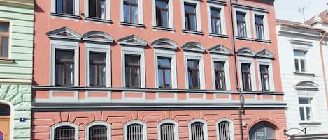 A multi-story building with a classic architectural style, featuring arched windows and decorative moldings.