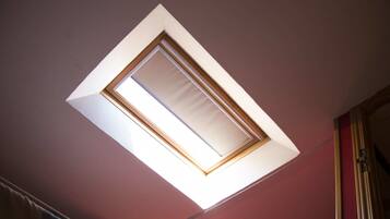 A skylight in a room with a red wall and a wooden door frame.