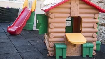 Children can play on this house with a slide and a bench.