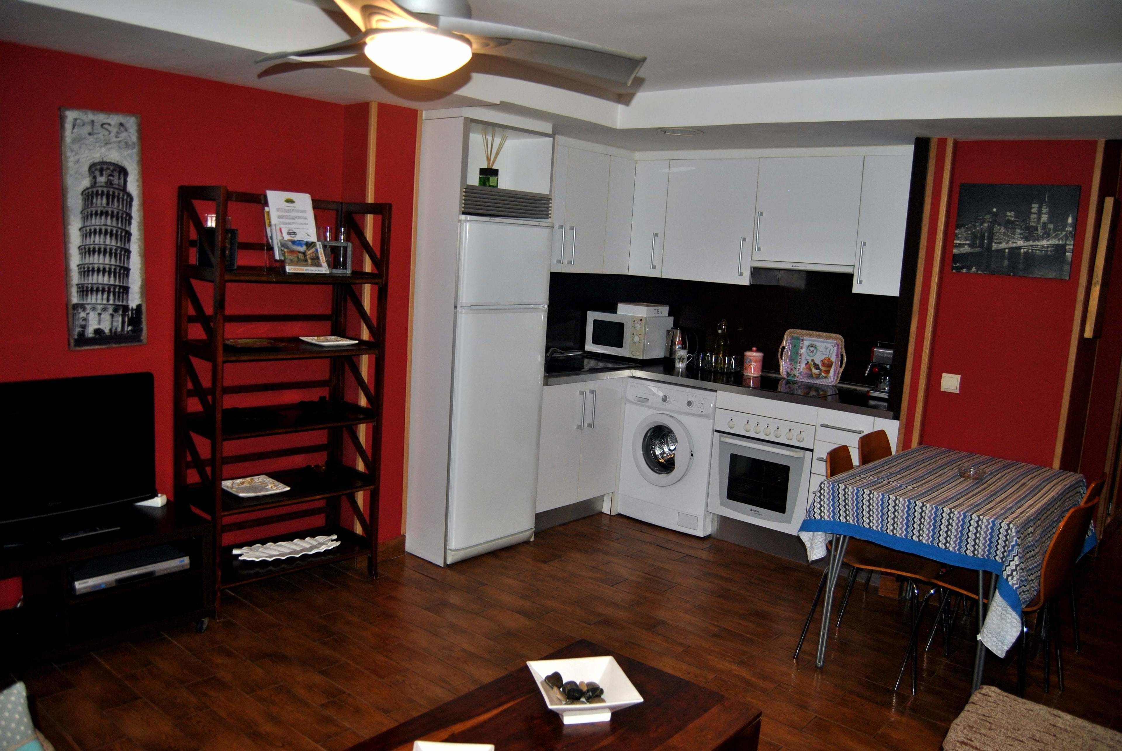 A compact living space with a kitchen, dining area, and entertainment unit.
