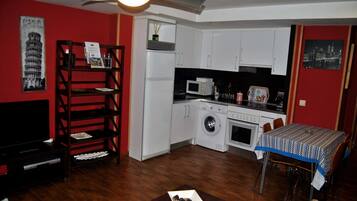 A compact living space with a kitchen, dining area, and entertainment unit.