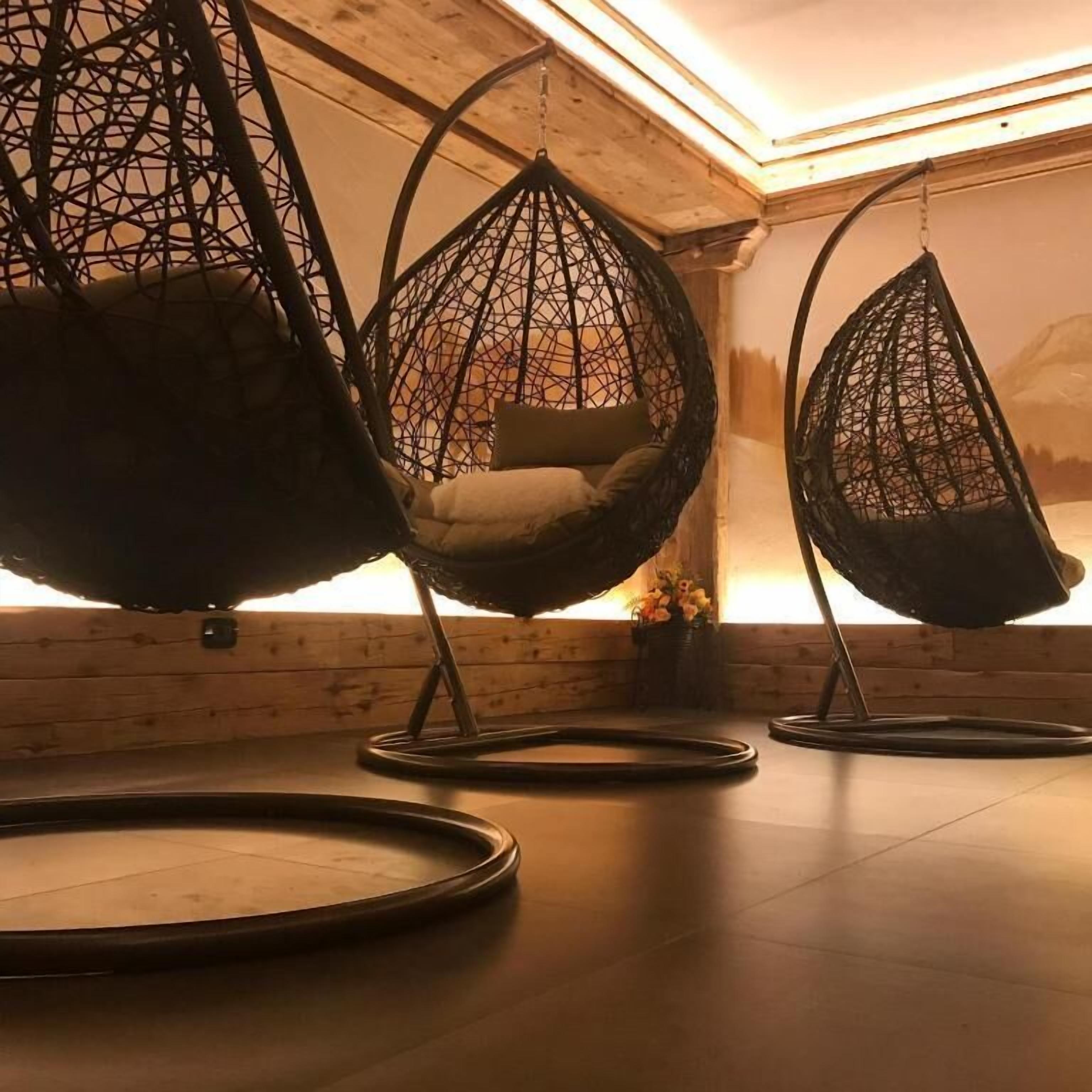 A room with three hanging chairs and a wooden floor.