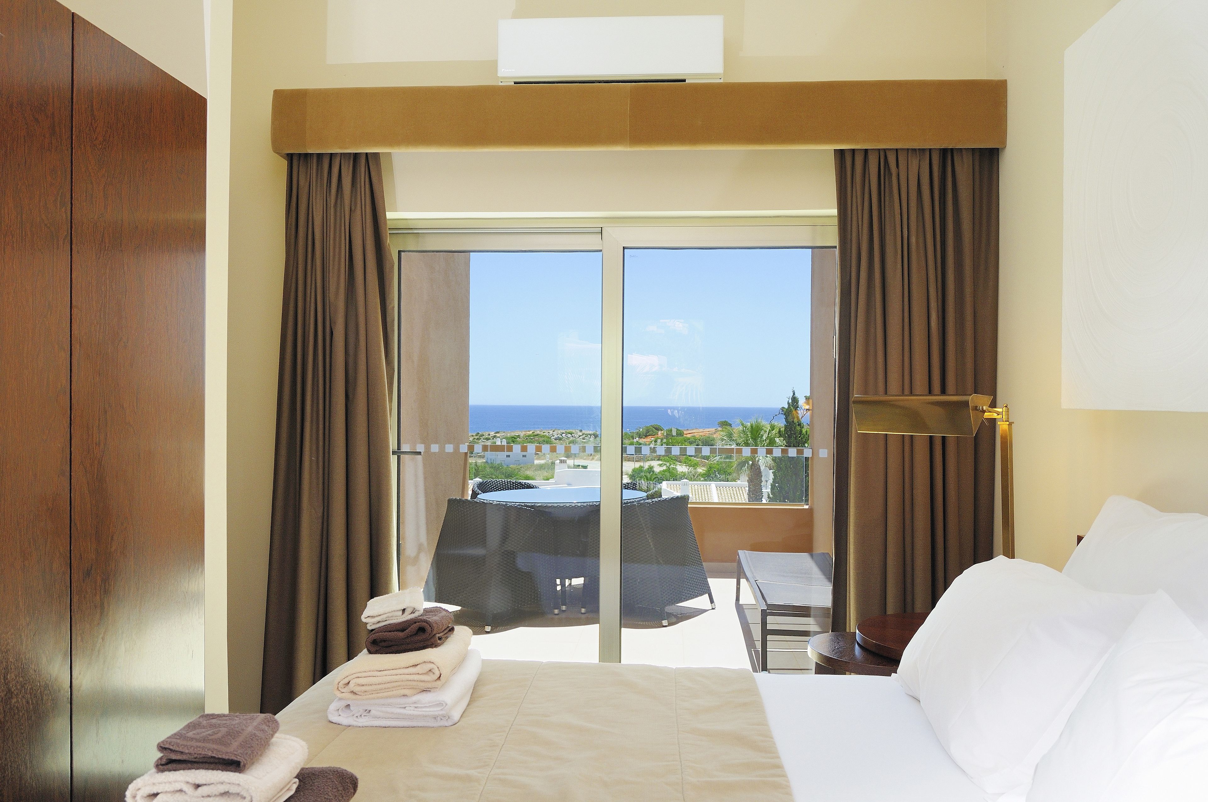 Una habitación de hotel con cama, una mesa y vista al mar.