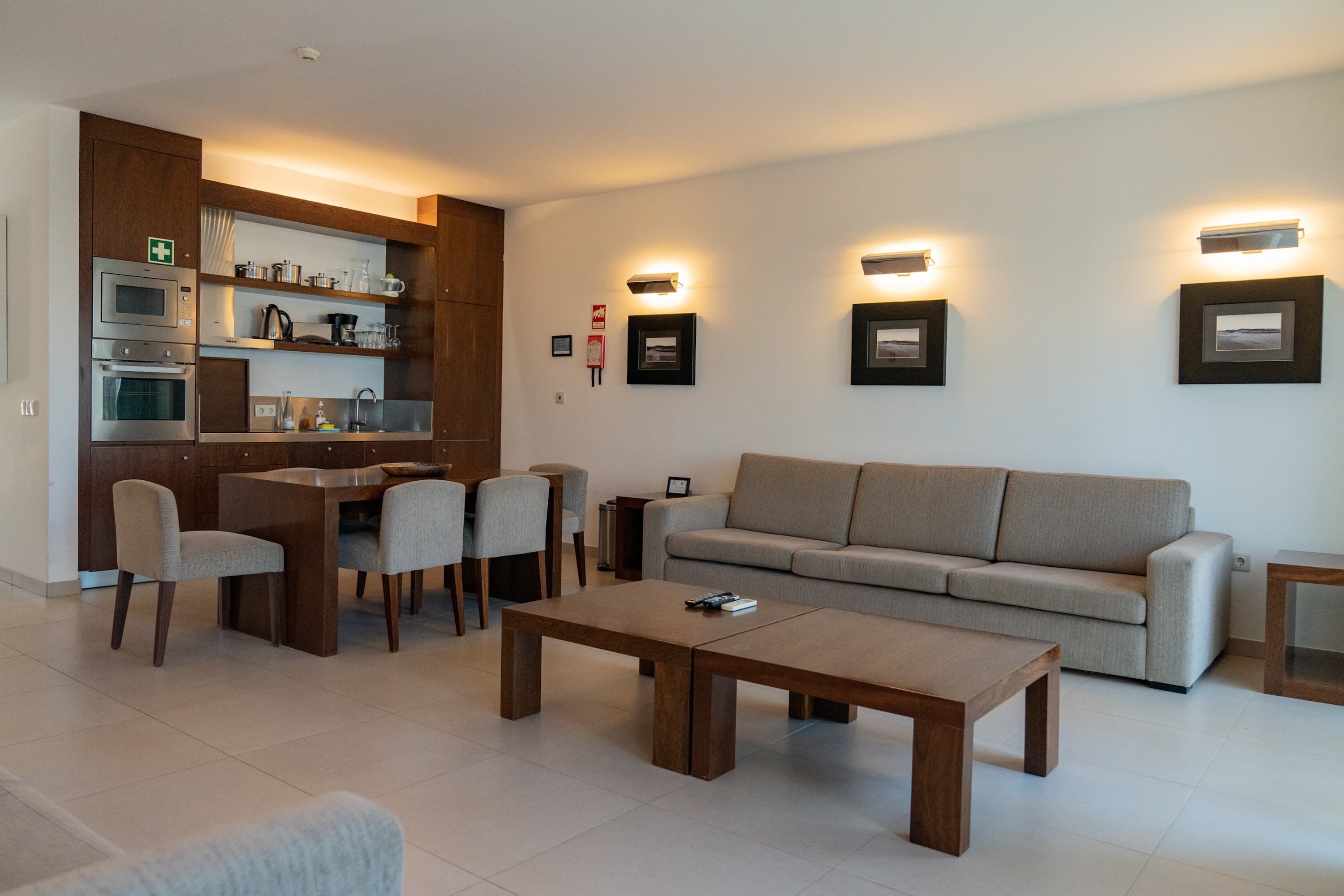 A modern living room with a sofa, coffee table, and dining area.
