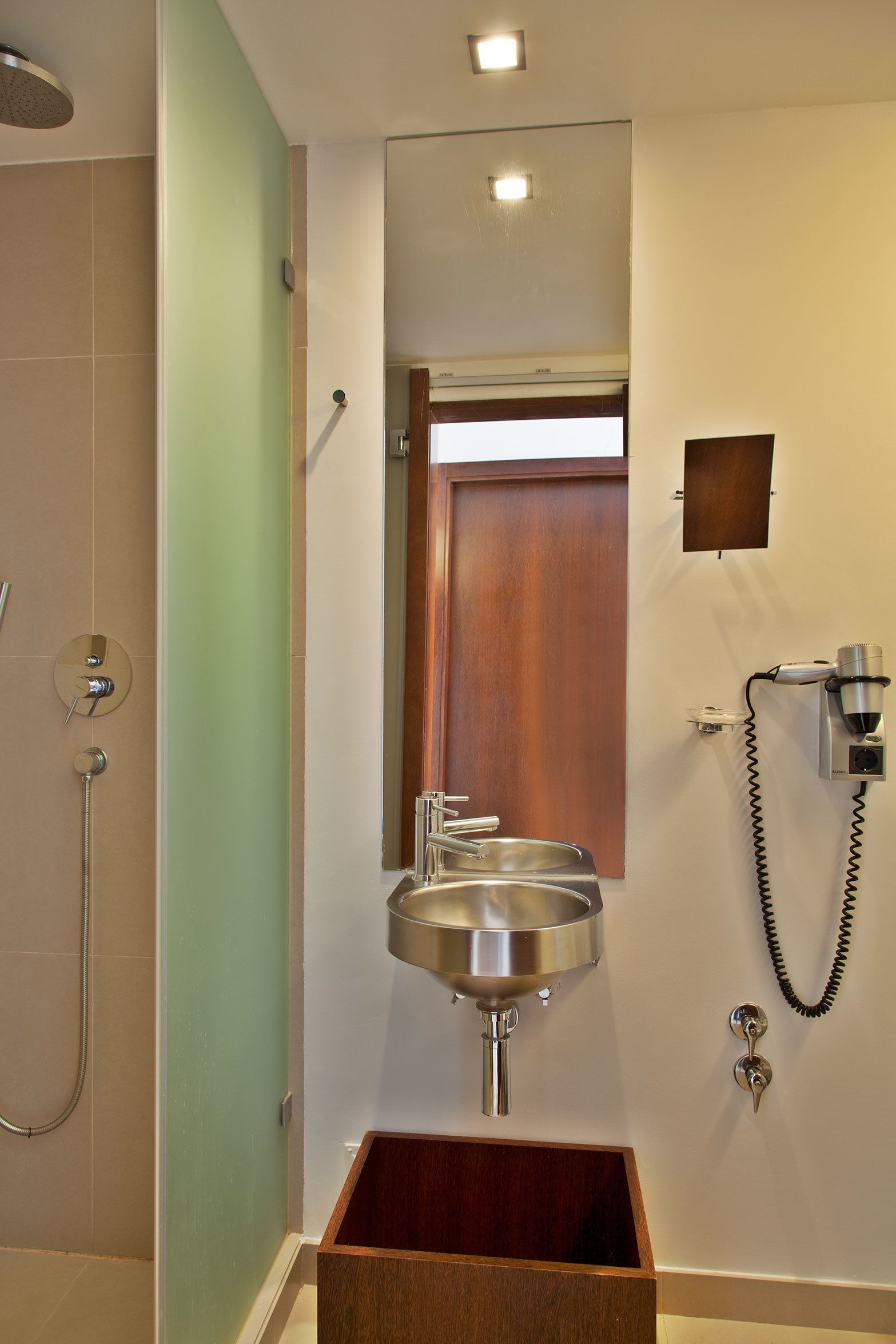 A bathroom with a shower, sink, and a mirror.