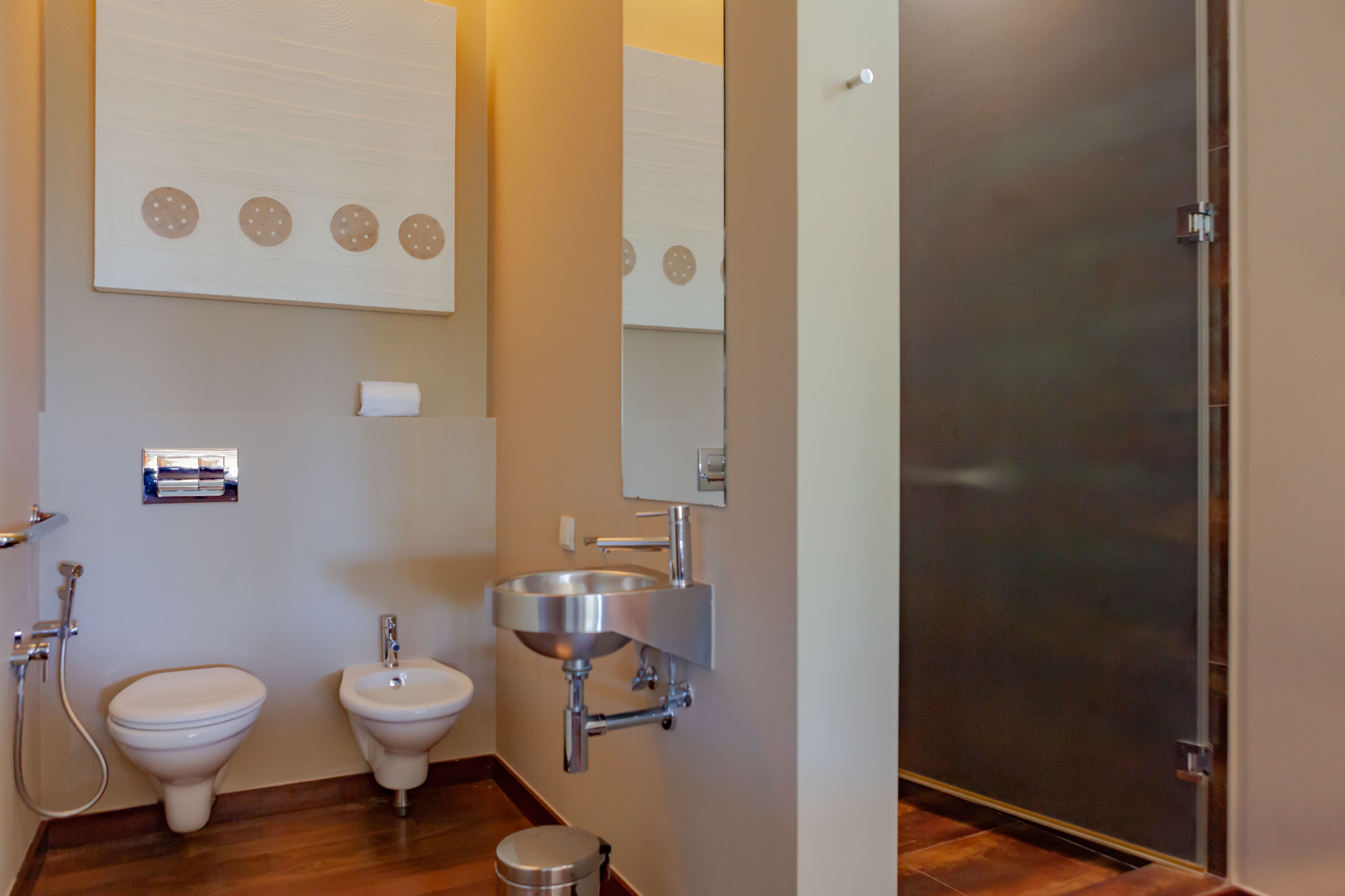 A bathroom with a toilet, bidet, and sink.
