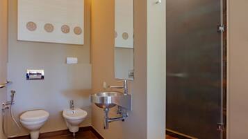 A bathroom with a toilet, bidet, and sink.