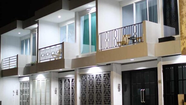 A multi-story residential building with balconies, large windows, and a gated entrance. - Just Inn Semarang (Semarang)