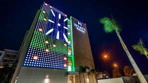 A tall building with a lit facade and a sign reading 'HYATT HOUSE'.