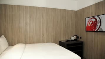 Una habitación de hotel con una cama grande, una mesita de noche y una obra de arte colgada en la pared.