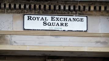 A stone archway with a sign reading 'Royal Exchange Square City Centre'.