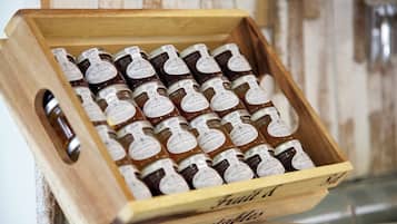 A wooden crate filled with jars of preserves, labeled with various flavors like raspberry and orange marmalade.