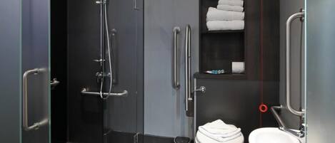 A modern bathroom with a glass-enclosed shower, a toilet, and a sink.