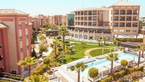 Un hotel amb diversos edificis, una piscina i un jardí ben cuidat.
