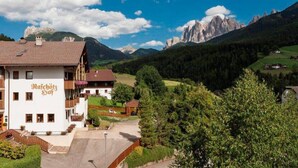 A mountain lodge with a white facade and a sign reading "Ratschöß". - Raschötzhof (Funes)