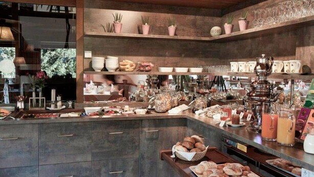 A kitchen with a central island, various kitchenware, and a display of tea boxes. - Raschötzhof (Funes)
