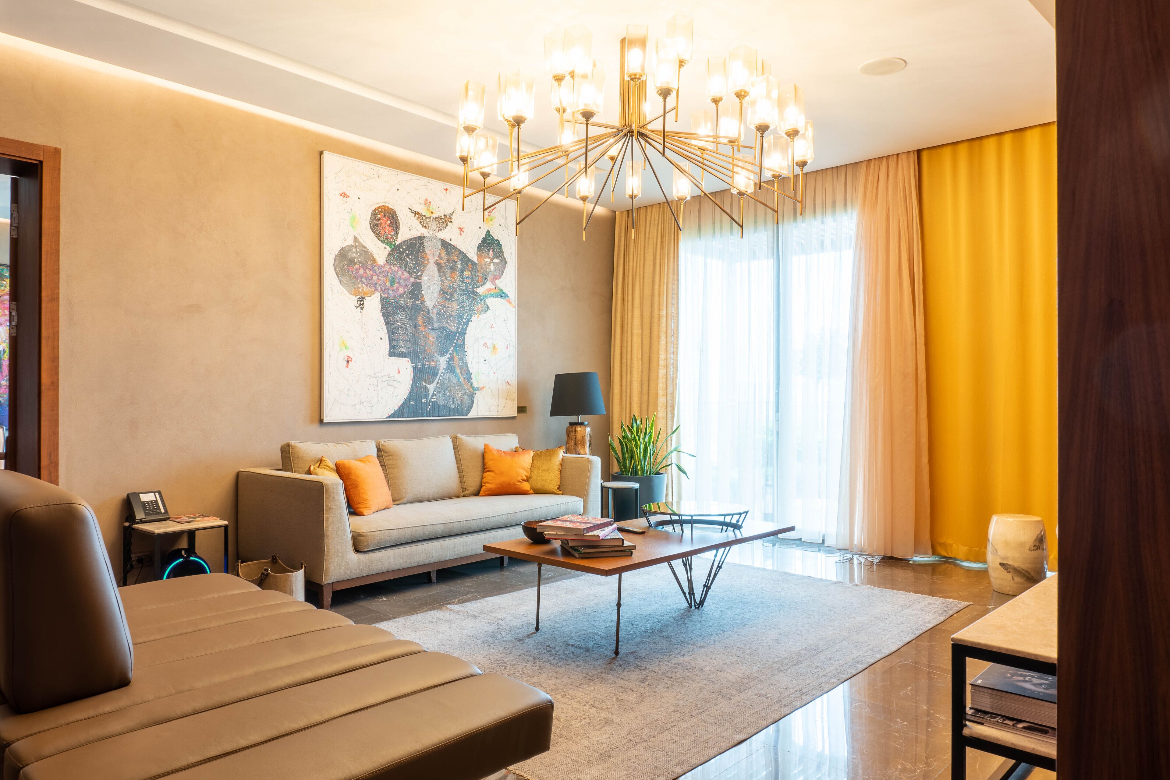 Een moderne woonkamer met een bank, een salontafel en een kroonluchter.