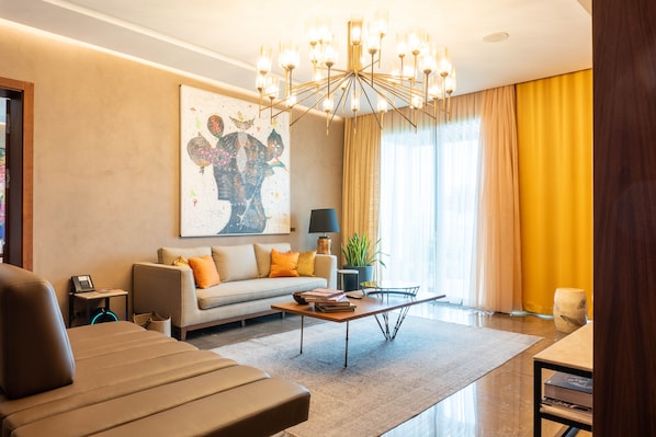 A modern living room with a sofa, a coffee table, and a chandelier.