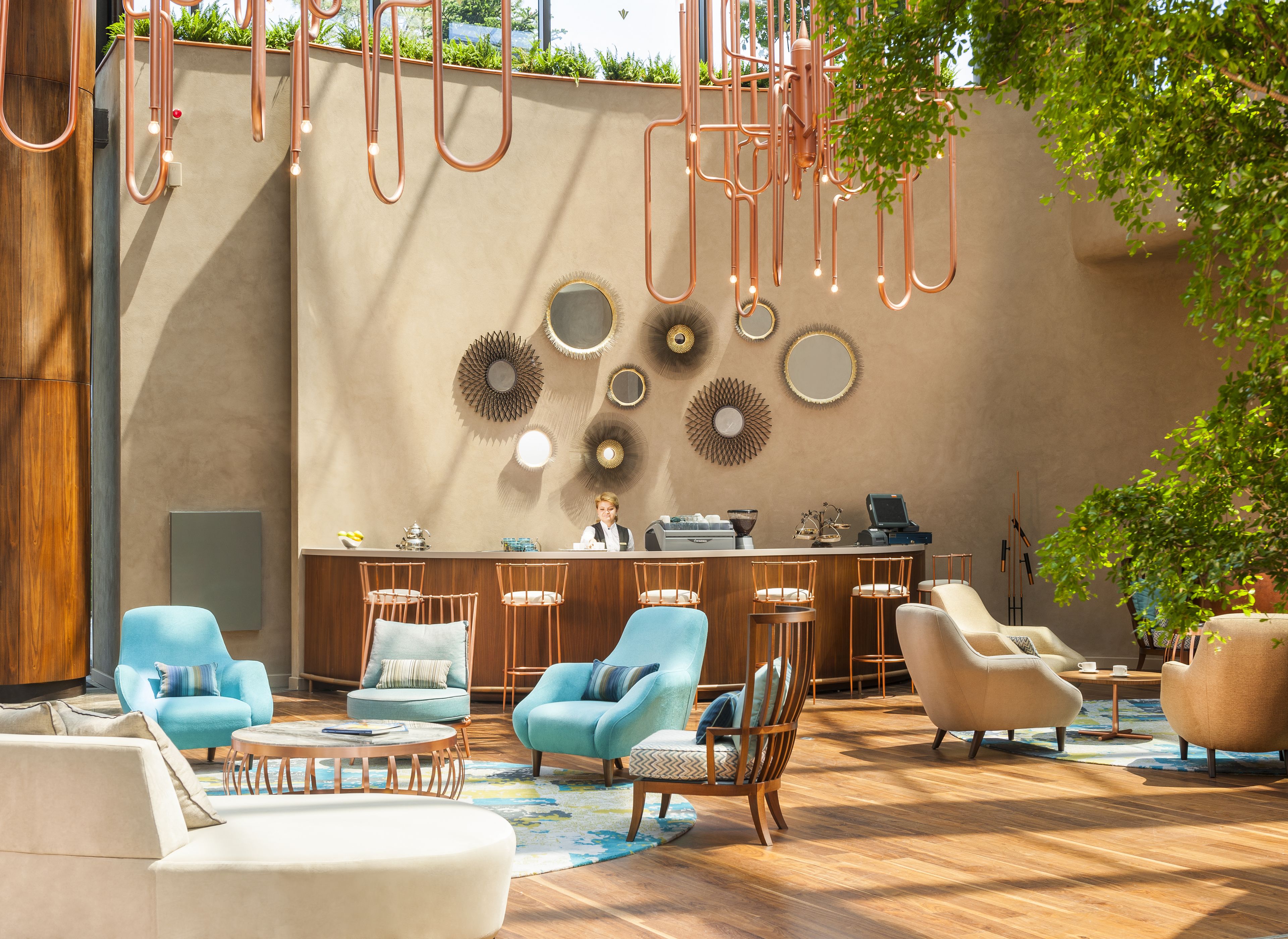 A modern lounge area with a bar, multiple seating options, and decorative wall art.