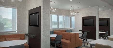 A modern conference room with a large window, a sofa, and a round table.