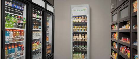 Una vetrina refrigerata con diverse bevande e un cartello con scritto 'helloGoodness'.