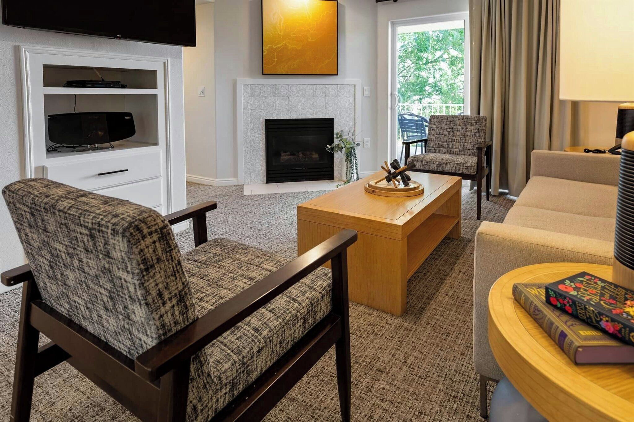 A modern living room with a flat-screen TV, a fireplace, and a comfortable seating area.