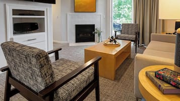 A modern living room with a flat-screen TV, a fireplace, and a comfortable seating area.