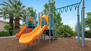 A playground with two slides and climbing structures.