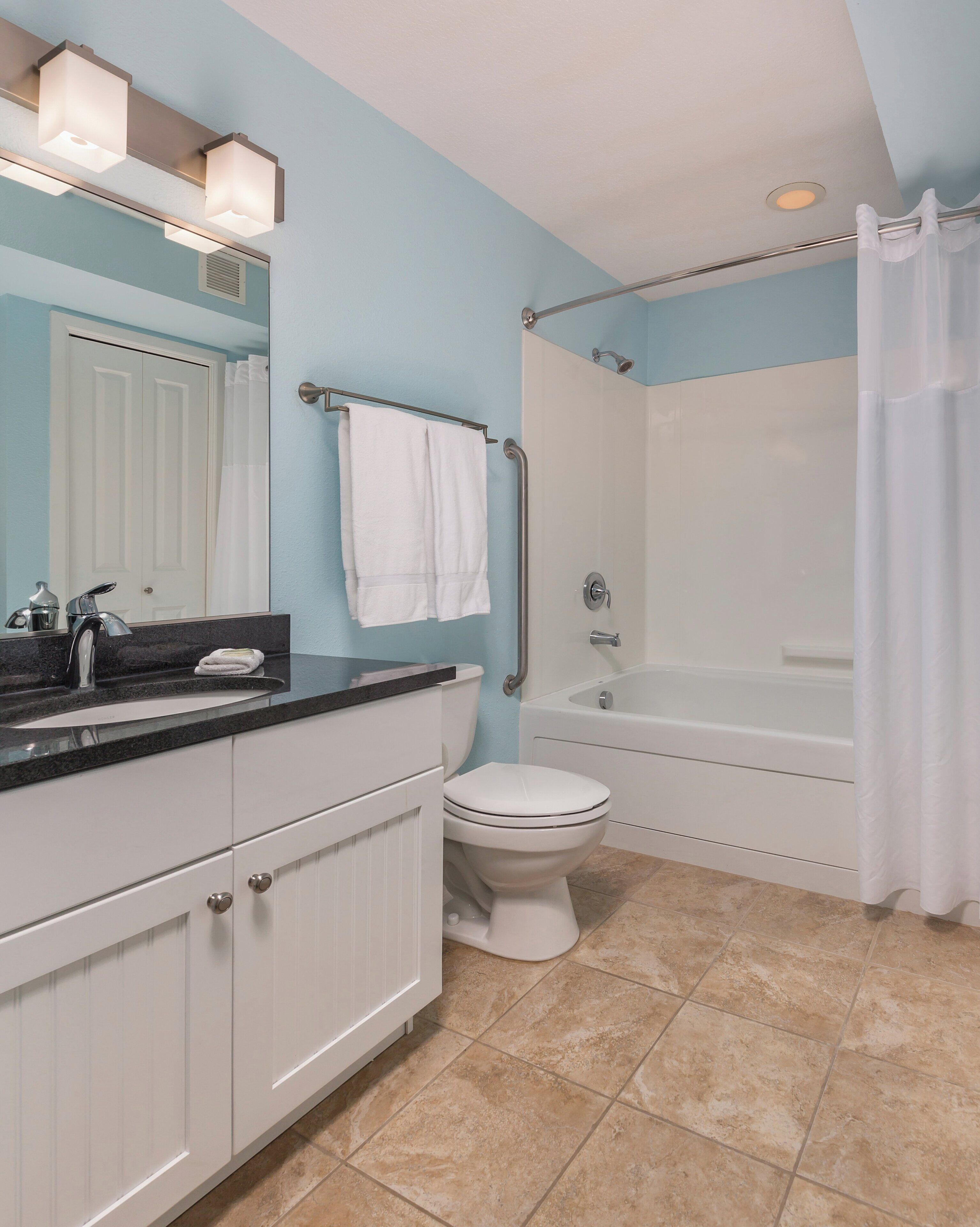 A bathroom with a white toilet, a bathtub, and a shower.