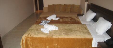 A hotel room with a large bed, a bedside table, and a nightstand.