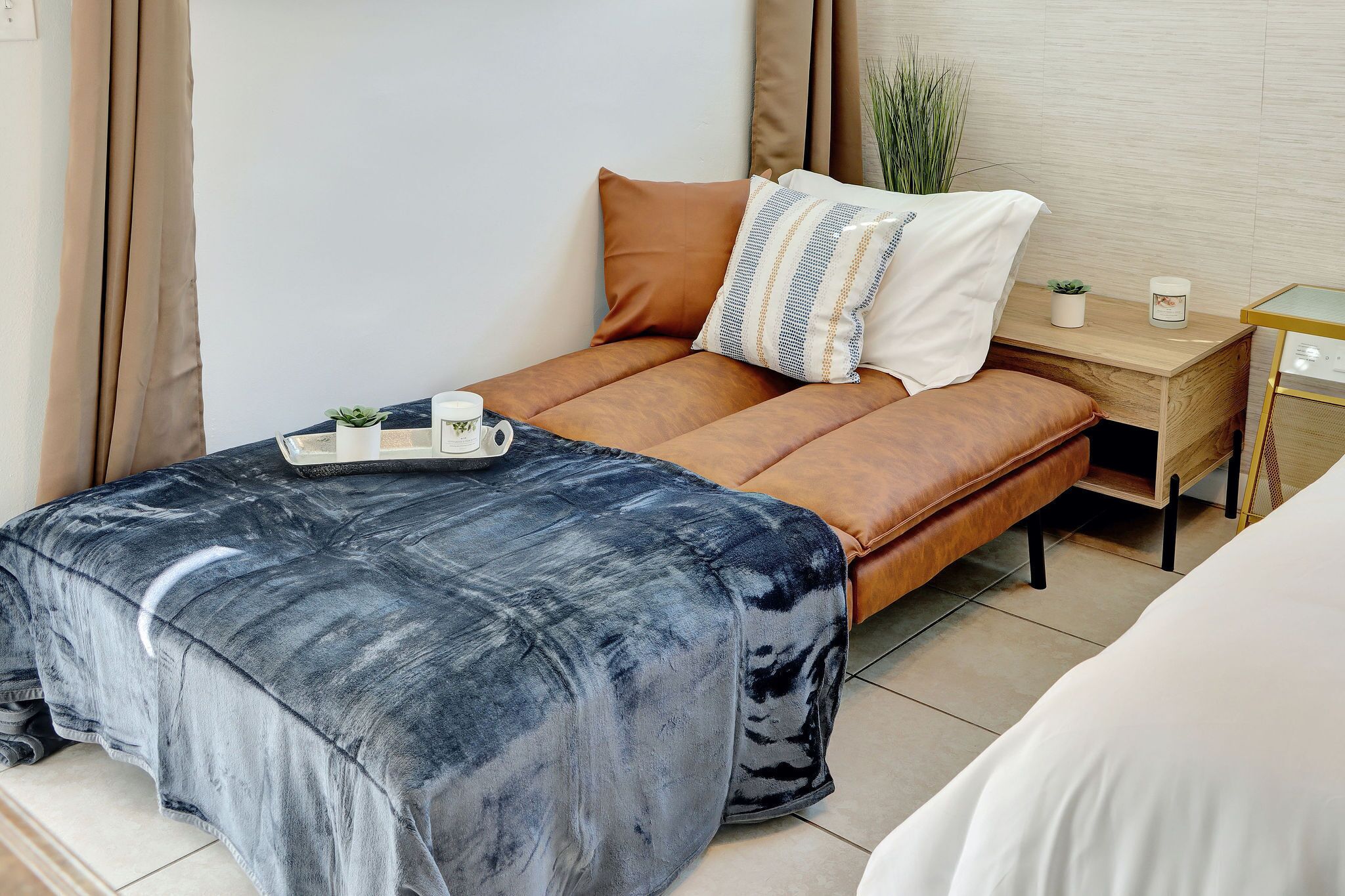Un dormitorio moderno con cama, mesita de noche y una pequeña planta en maceta.
