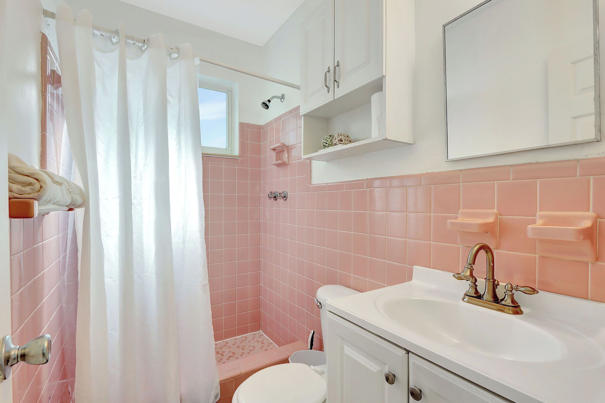 Une salle de bain équipée d’une douche, de toilettes, d’un lavabo et de meubles de rangement.