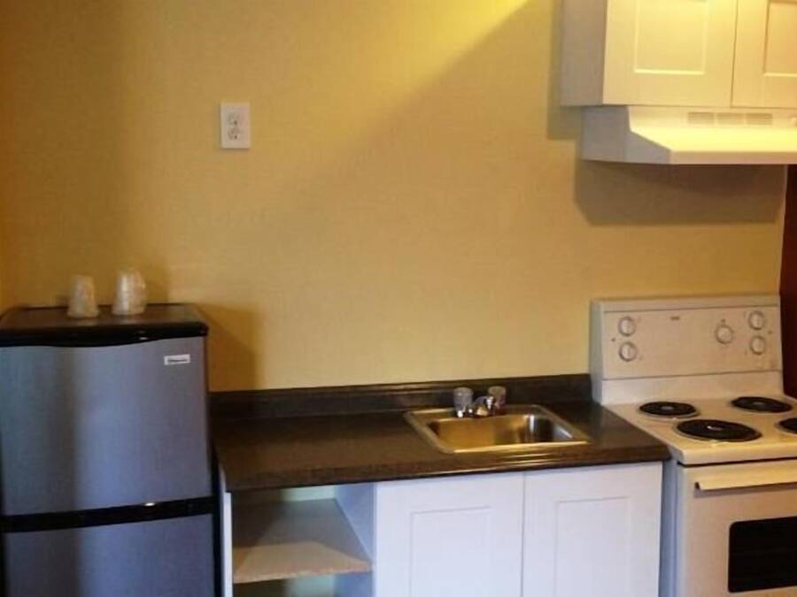 A compact kitchen with a refrigerator, stove, and sink.