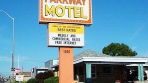 A motel sign with a yellow and white color scheme, featuring the name 'Parkway Motel' and a smaller sign below stating 'Best Rates' and 'Weekly and Commercial Rates Free Internet'. - Parkway Motel (London)